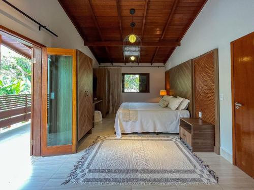 a bedroom with a bed and a sliding glass door at Casa Luna - Elegante c/ Enxoval Completo - Riviera in Riviera de São Lourenço