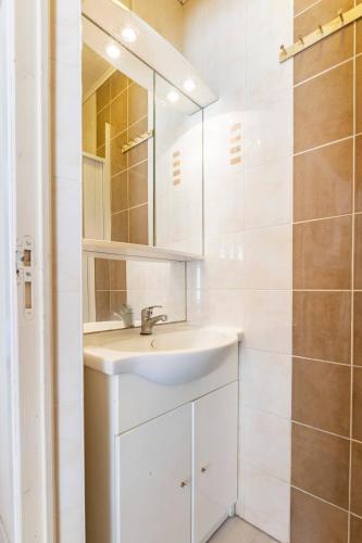 une salle de bain blanche avec un lavabo et un miroir dans l'établissement Gite d en Bas, à Sarlat-la-Canéda