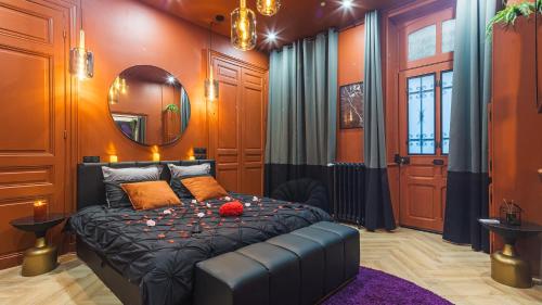 una camera da letto con un letto e uno specchio di La Clé des Sens - Univers Envoûtant et Sensuel a Troyes