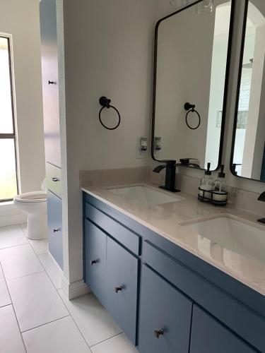 a bathroom with a sink and a large mirror at The Ultimate Staycation in San Antonio
