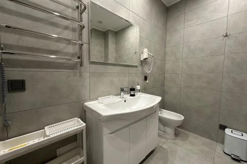 a bathroom with a sink and a toilet and a mirror at "Гірський Континент" Hotel Restaurant & SPA in Yablunytsya
