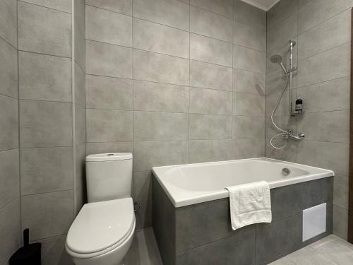 a bathroom with a toilet and a bath tub at "Гірський Континент" Hotel Restaurant & SPA in Yablunytsya