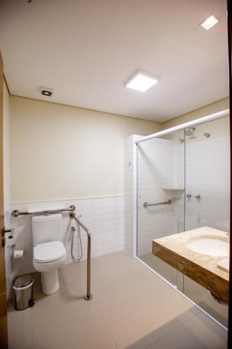 a bathroom with a toilet and a shower and a sink at Ipê Palace Hotel in Adamantina