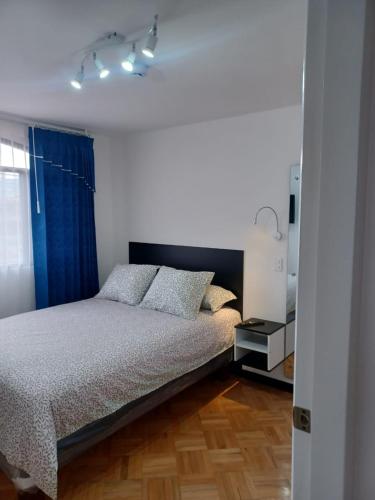 a bedroom with a bed and a blue curtain at Casa Sharlen in Hacienda El Tambo