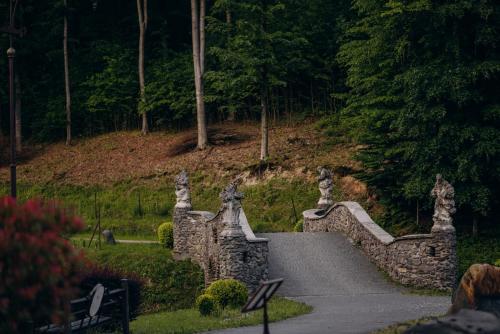 a stone bridge with statues on the side of a road at Voevodyno Resort in Tur'ya Pasika