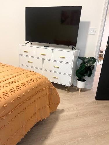 a white dresser with a flat screen tv on it at Cozy 1BR with Private Balcony, Gym, Pool & Workspace in Richmond