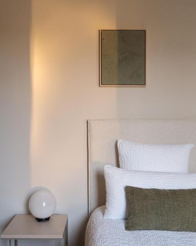 a bedroom with a bed and a table with a lamp at Lits de Lo - Boutique Rooms in Ghent
