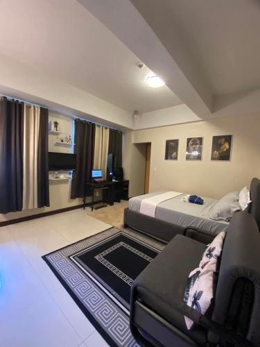a bedroom with a bed and a chair and a couch at A&G Condotel at 101newport Near NAIA T3 in Manila