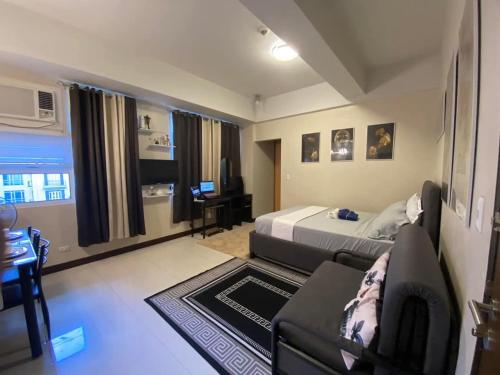 a bedroom with a bed and a couch and a desk at A&G Condotel at 101newport Near NAIA T3 in Manila