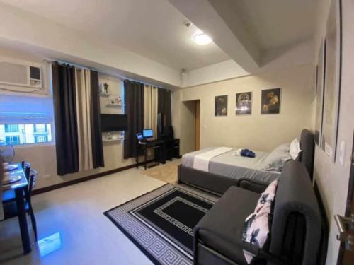 a bedroom with a bed and a couch and a desk at A&G Condotel at 101newport Near NAIA T3 in Manila