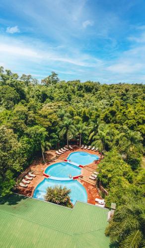 an aerial view of a resort pool with chairs and trees at La Aldea De La Selva Lodge in Puerto Iguazú