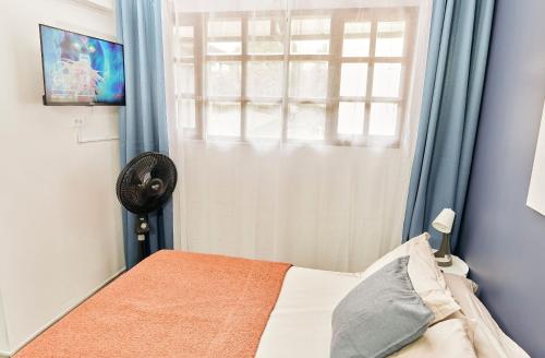 a small bedroom with a bed and a window at Apartahotel Poblado-Aguacatala in Envigado