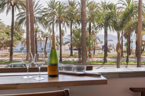 une bouteille de vin posée sur une table avec des verres dans l'établissement La Réale Croisette, à Cannes