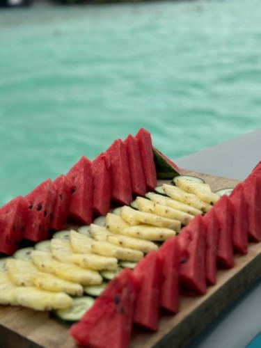 a cutting board with slices of bananas and watermelon at Hotel & Eco Cabañas Azul María Bacalar- Gratis Club de playa in Bacalar