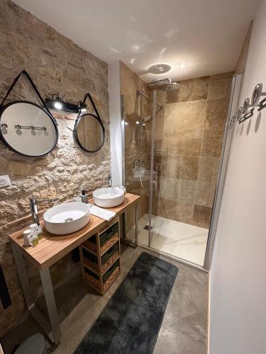 une salle de bain avec deux lavabos et une douche dans l'établissement Les Gîtes du Fournil des Moines, à Clermont-Dessous