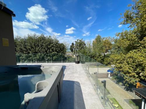 a swimming pool with a glass fence next to a house at Optimus Residence in Balatonföldvár