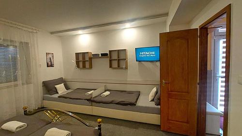 a bedroom with a bed and a tv on the wall at Holiday Apartman in Mórahalom