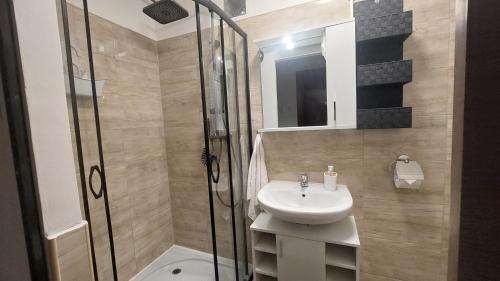 a bathroom with a sink and a glass shower at Holiday Apartman in Mórahalom