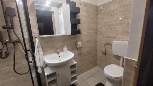 a bathroom with a sink and a toilet at Holiday Apartman in Mórahalom
