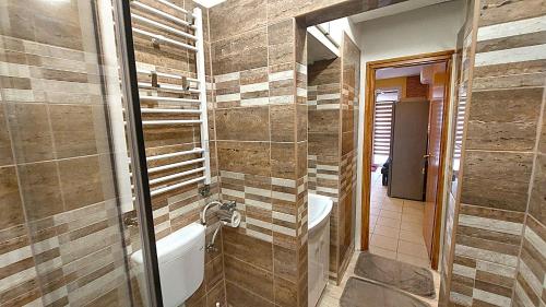 a bathroom with a bath tub and a sink at Holiday Apartman in Mórahalom