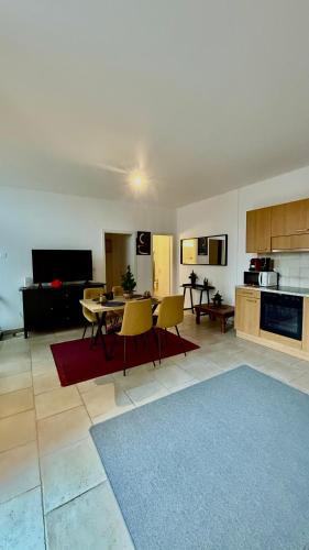 a living room with a table and chairs and a kitchen at Joli Appartement terrasse Montreux in Clarens