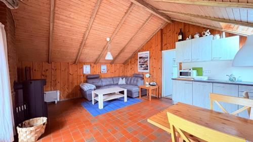 eine Küche und ein Wohnzimmer mit einem Sofa und einem Tisch in der Unterkunft Ferienhaus "Sören" in Glücksburg