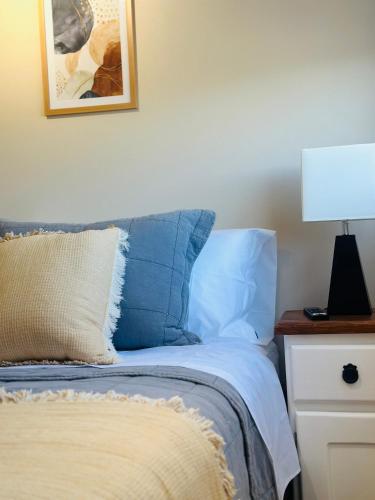 - un lit avec des oreillers bleus et une lampe sur une table de nuit dans l'établissement Departamento Dual Prieto, à Concepción