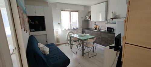 a small kitchen with a table and a blue couch at Piranesi in Menton