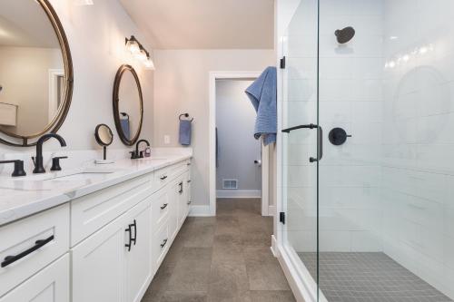 a bathroom with two sinks and a shower at Toes in the Water , pool , perfect for large groups in South Haven