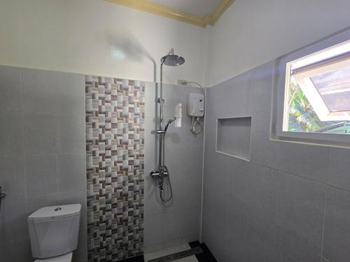 a bathroom with a shower with a toilet and a window at Bregman Residance in Plaridel