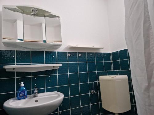 a bathroom with a white sink and a toilet at Feriengarten Dahme W 21 in Dahme