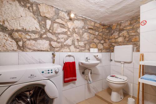 une salle de bains avec lave-linge et lavabo dans l'établissement House Bozica with sauna and pool, à Tribalj
