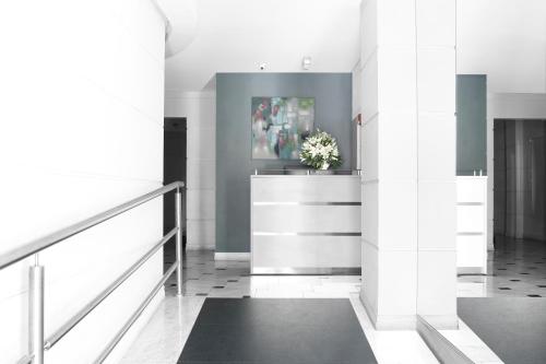 a hallway with white walls and a vase of flowers at CH Recoleta Suites in Buenos Aires