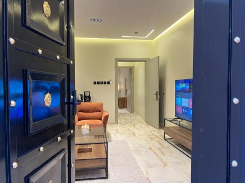 a living room with a couch and a television at سويت بغرفة نوم وصالة جانبية in Hail