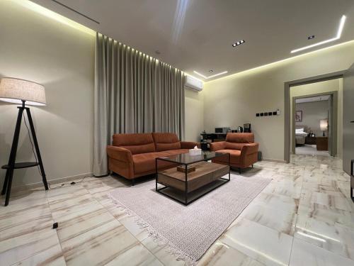 a living room with two couches and a table at سويت بغرفة نوم وصالة جانبية in Hail