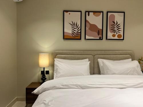 a bedroom with a bed with four pictures on the wall at سويت بغرفة نوم وصالة جانبية in Hail