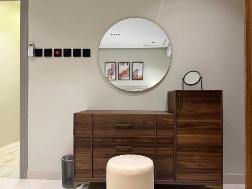 a mirror on a wall next to a wooden dresser at سويت بغرفة نوم وصالة جانبية in Hail