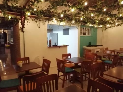 a dining room with tables and chairs and lights at Hostal las margaritas in Pasto