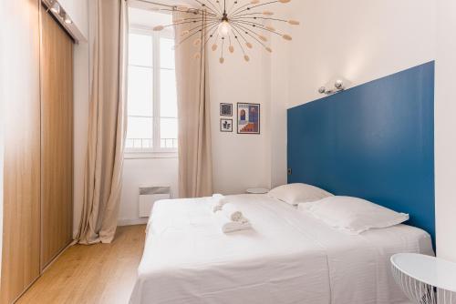 une chambre avec un grand lit blanc avec une tête de lit bleue dans l'établissement 