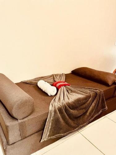 a brown bed with two towels on top of it at Pousada Casinha Amarela - Campos do Jordão in Campos do Jordão
