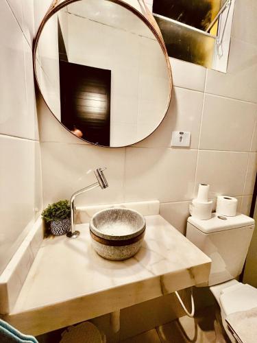 a bathroom with a sink and a mirror at Pousada Casinha Amarela - Campos do Jordão in Campos do Jordão