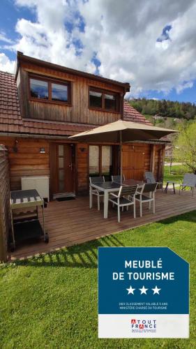 une maison avec une terrasse avec une table et des chaises dans l'établissement Valley Lodge, à La Bresse