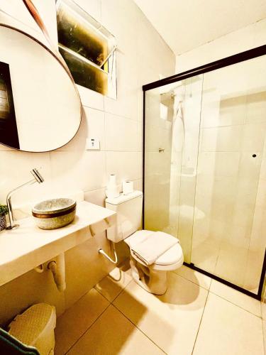 a bathroom with a toilet and a sink and a shower at Pousada Casinha Amarela - Campos do Jordão in Campos do Jordão