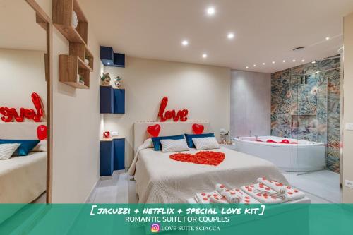 a bedroom with a bed and a tub with a heart pillow at !!! IDROMASSAGGIO !!! - Love Suite in Sciacca