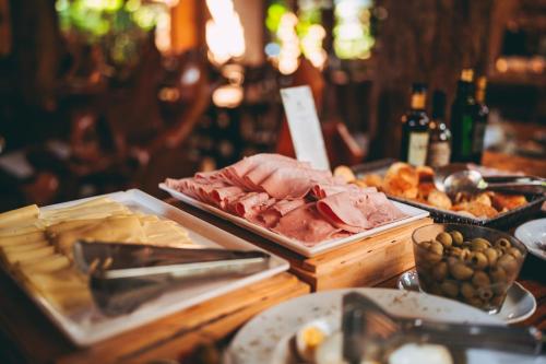 a buffet with meat and other food on a table at La Aldea De La Selva Lodge in Puerto Iguazú