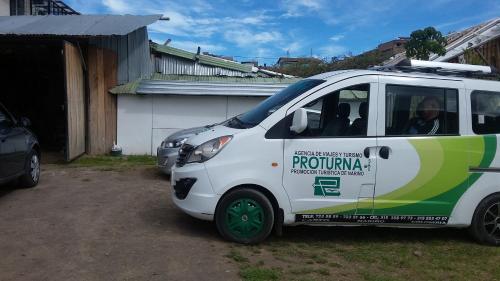 a white and green van parked in front of a house at Hostal las margaritas in Pasto