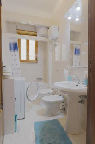 a white bathroom with a toilet and a sink at Goccia Perla - Gocce sul Mare in Torre Canne