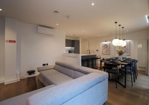 a living room with a couch and a dining room at Elysium by The Heim in Manchester