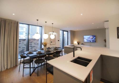 a kitchen and living room with a table and chairs at Elysium by The Heim in Manchester