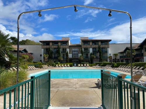 une piscine devant un immeuble dans l'établissement Appartement Moliets Plage Golf, à Moliets-et-Maa